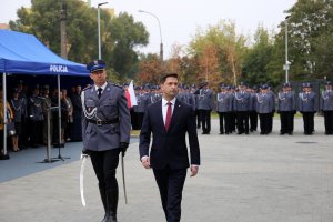 Wiceminister MSWIA idzie z dowódcą uroczystości wzdłuż kompanii reprezentacyjnej policji.