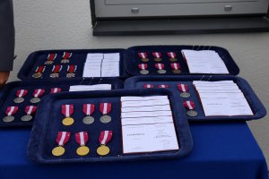 Medale oraz legitymacje dla wyróżnionych funkcjonariuszy.