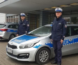 fot. policjanci przed komendą i radiowóz