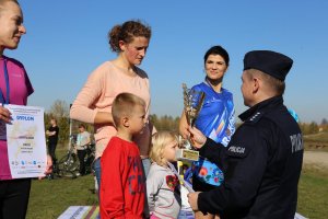 komendant wręcza puchar zwyciężczyni biegu