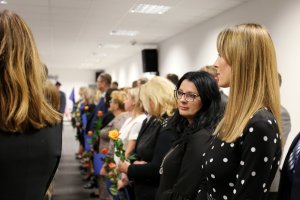 wyróżnieni pracownicy cywilni trzymają w ręku róże