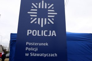 Tablica informacyjna z napisem Posterunek Policji w Sławatyczach.
