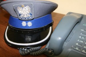czapka policyjna leżąca przy telefonie stacjonarnym