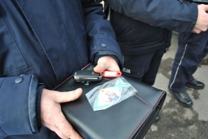 fot. policjant trzyma kluczyki i obrazek św. Krzysztofa