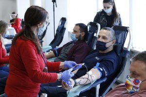 Zastępca Komendanta Wojewódzkiego Policji w Lublinie oddaje krew za nim an foteli inny funkcjonariusz również oddaje krew.