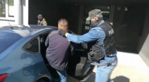 policjanci prowadzą zatrzymanego