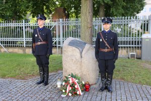 kwiaty pod pomnikiem poświęconym pomordowanym policjantom II Rzeczypospolitej
