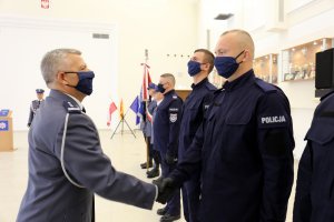 Komendant Wojewódzki Policji w Lublinie podaje rękę nowemu funkcjonariuszowi gratulując wstąpienia w szeregi.