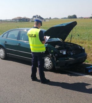 policjant i uszkodzony samochód