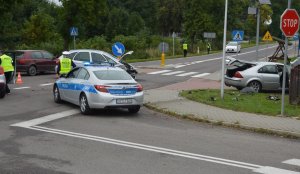 Rozbite dwa samochody stojące na drodze oraz oznakowane radiowozy i policjanci