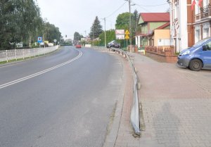 volkswagen passat stojący dwoma kołami na barierce po prawej stronie niebieski bus
