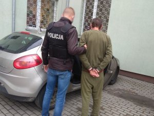 zatrzymany mężczyzna doprowadzony przez policjanta