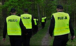 policjanci poszukujący zaginionego w lesie