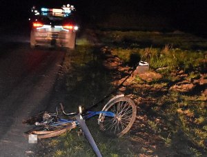 Zdjęcie miejsca wypadku. Uszkodzony rower i radiowóz