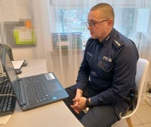 policjant przy komputerze podczas prelekcji