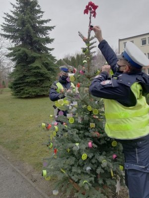 policjanci wieszający odblaski na choinkę