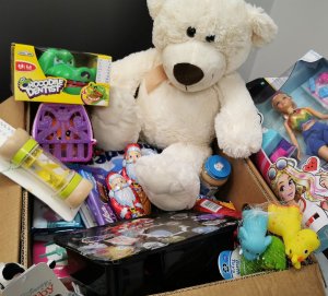 pudełko z prezentami dla dzieci, w którym znajdują się misie, lalka, zabawka dla niemowląt
