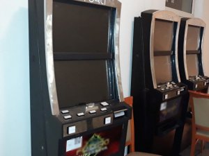 Trzy automaty do gier stojące w pomieszczeniu