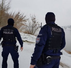 dwóch policjantów idących brzegiem Wisły
