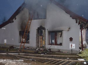 Zniszczony budynek  po wybuchu gazu. Widoczne uszkodzone otwory okienne oraz drzwi wejściowe.