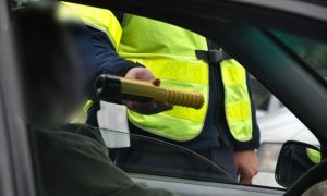policjant poddaje kierowcę pojazdu badaniu stanu trzeźwości