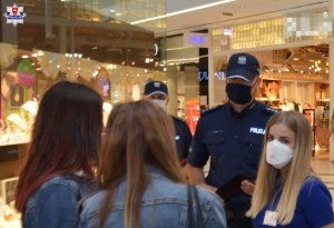 policjanci wspólnie z przedstawicielką sanepidu z klientkami galerii