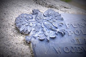 Godło Polski umieszczone na kamiennym pomniku.