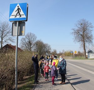 Policjantki i grupa dzieci z opiekunami przed przejściem dla pieszych