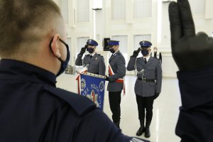policjant składa ślubowanie, w tle poczet sztandarowy