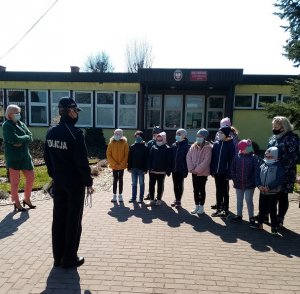 policjantka z grupą dzieci i opiekunami podczas pogadanki