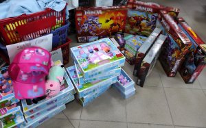 Zdjęcie przedstawia zabezpieczone zabawki z podrobionymi znakami towarowymi ustawione na podłodze