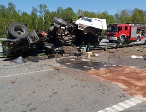 rozbita ciężarówka na drodze w tle wóz strażacki