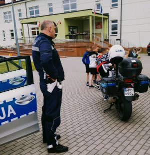 pokaz policyjnego motocykla. Policja prezentuje chłopcom motocykl.