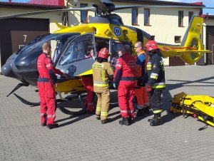 akcja ratunkowa, strażacy i ratownicy transportują poszkodowanego do śmigłowca