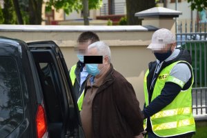 policjanci prowadzą sprawcę