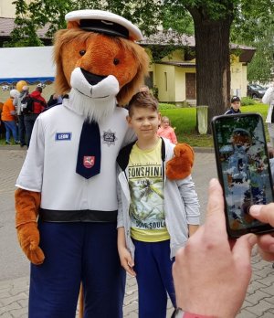Policyjna maskotka lwa z dzieckiem pozują do zdjęcia