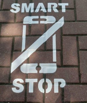 namalowana grafika na chodniku, napis Smart Stop