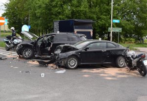Dwa uszkodzone pojazdy, motocykl i policjant na jezdni w Zamościu