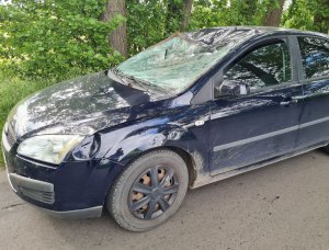uszkodzona przednia część pojazdu samochodu osobowego marki ford, koloru granatowego, zbita szyba