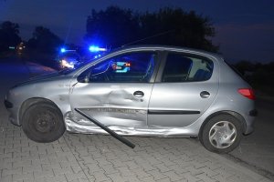 uszkodzony samochód marki Peugeot stojący częściowo na poboczu