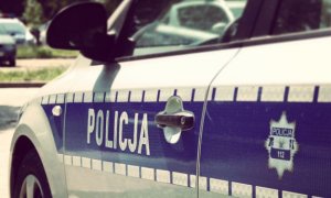 bok radiowozu, na którym widać napis Policja