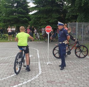 policjant umundurowany oraz uczeń na rowerze podczas egzaminu na kartę rowerową