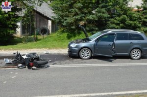 rozbity motocykl leży na jezdni obok uszkodzony samochód
