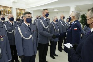 Komendant Wojewódzki Policji w Lublinie odznacza funkcjonariusza medalem. Po prawej stronie zdjęcia Wojewoda Lubelski trzyma legitymację, którą za chwilę wręczy.