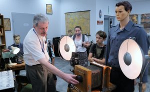 pracownik pokazuje uczniom stary aparat fotograficzny