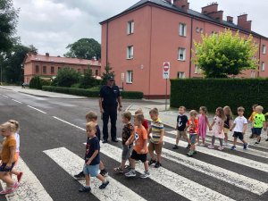 policjant uczy dzieci przechodzenia przez przejście