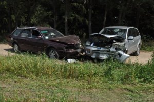 Zderzenie dwóch pojazdów w powiecie bialskim. Zniszczone pojazdy na trawie.