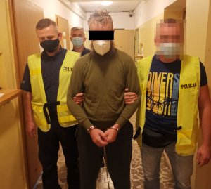 zatrzymany mężczyzna w kajdankach, obok policjanci