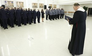 Kapelan lubelskiej policji błogosławi nowych funkcjonariuszy.