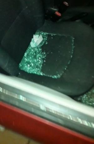 fragmenty wybitej szyby lezące na siedzeniu uszkodzonego samochodu